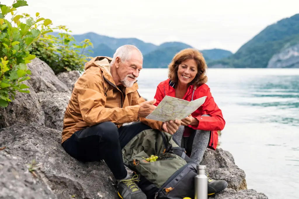 Mature-couple-hiking-looking-at-map-scaled - Your Savvy Purse