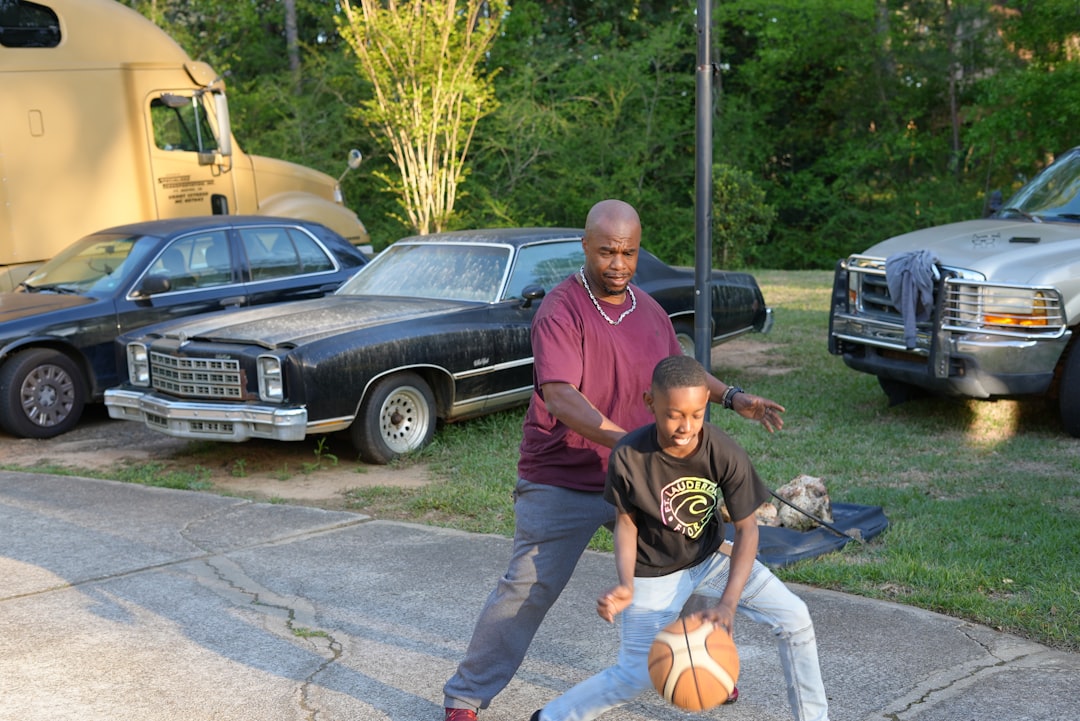Athletic dad playing basketball with his son