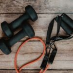 Two dumbbells and a resistance band laid out for a home strength workout