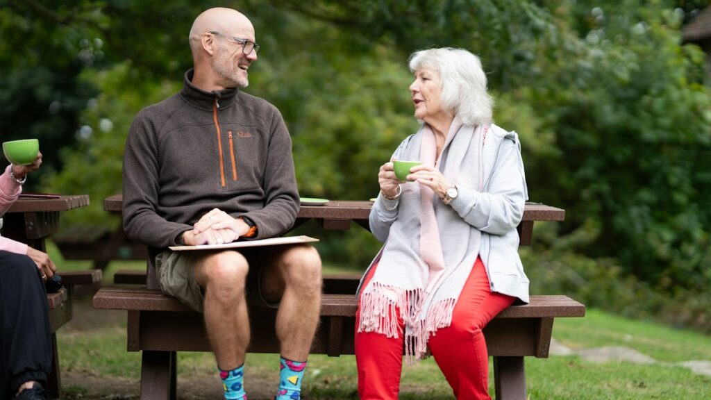 A man and a woman sitting together on a park bench