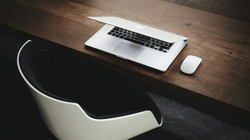 Laptop beside a computer mouse on a table