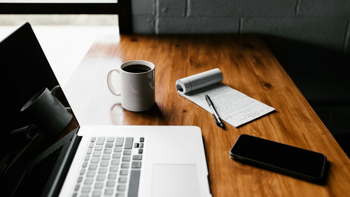 Laptop, coffee mug and smartphone on a desk