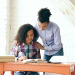 Mother helping daughter with homework at a desk