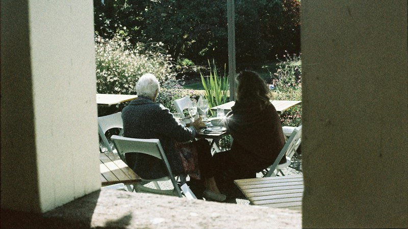People sitting at a table under an umbrella